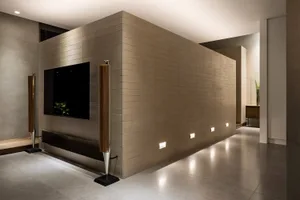A modern, minimalist living room with a tiled wall and floor.