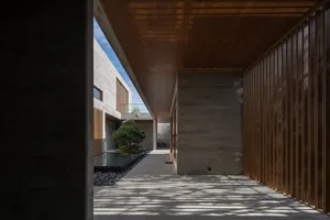 A minimalist design featuring a courtyard with concrete walls and wooden paneling.