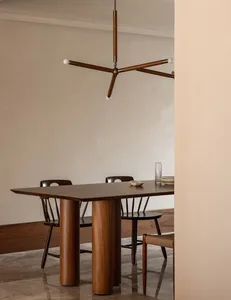 Modern dining room featuring wooden furniture and a minimalist chandelier.