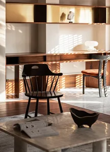 Modern home office space featuring a wooden desk with seating arrangements and decorative items.