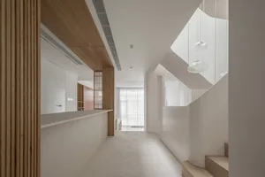 A modern living room with white walls, wooden elements, and a minimalist design.