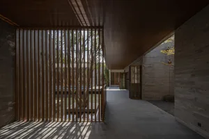 Interior view of a modern, minimalist corridor with concrete and wood elements.