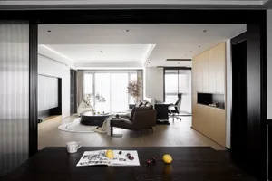 Modern minimalist living room featuring sleek, black furniture and natural wood accents.