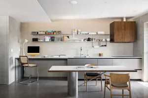 Modern minimalist kitchen with concrete, wood, and metal materials.