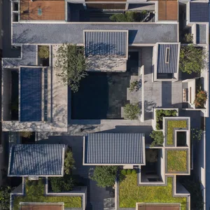 Aerial view of a modern residential courtyard with concrete structures, glass elements, and greenery.