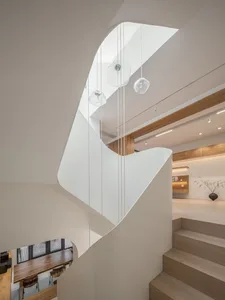 A modern interior design featuring a white concrete staircase with glass pendant lights.