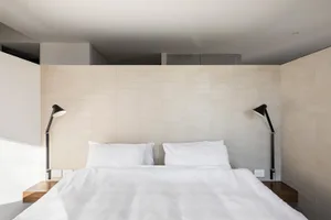 A minimalist white bedroom with modern design elements.