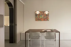 Modern kitchen with wooden table and chairs, featuring minimalist design elements.