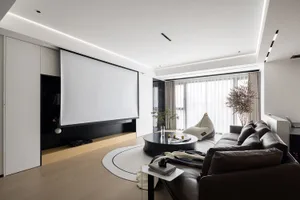 Modern living room featuring a large white screen, a brown leather sofa, and a round coffee table with plants and decor.