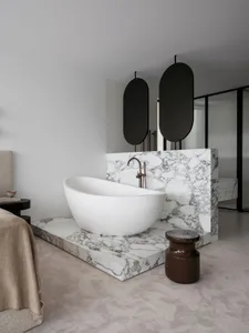 A modern marble bathroom with a freestanding bathtub and minimalistic design.