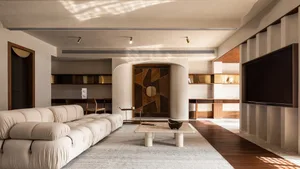 Modern minimalist living room featuring a creamy-colored leather sofa, a marble coffee table, and a wooden geometric wall pan