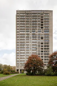 A modern residential high-rise building made of concrete and glass.