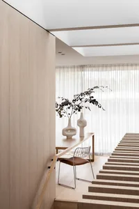 A modern minimalist interior with wooden furniture and leather accents.