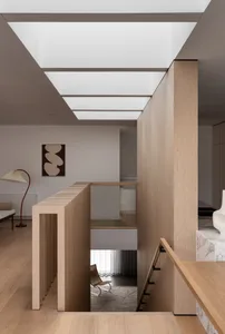 Modern minimalist residential staircase featuring wooden panels and marble elements.