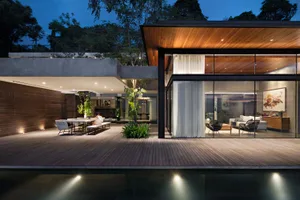 Modern residential space featuring wooden flooring, glass walls, and concrete elements.