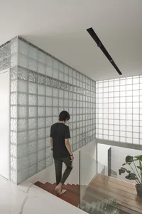 A modern staircase interior featuring glassblocks and marble.