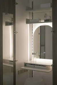 A modern vanity with white materials and illuminated lighting.