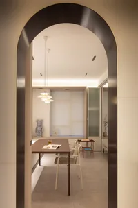 現代簡約空間，白牆搭配木質餐桌、白椅與吊燈。