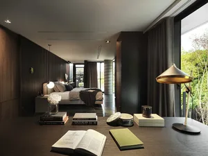 A modern bedroom featuring dark wood, fabric upholstery, and a glass window.