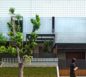 Greenery adorns the glass and wooden exterior of a modern building.
