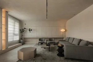 Modern, minimalist living room featuring concrete materials and a neutral color palette.