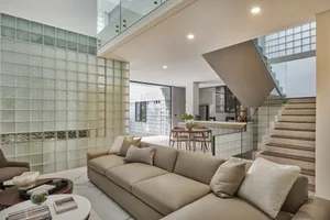 A modern living room with a glass wall and marble accents