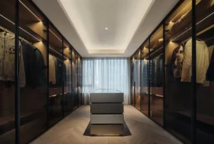 Modern walk-in closet with glass doors, white drawers, and wooden flooring.