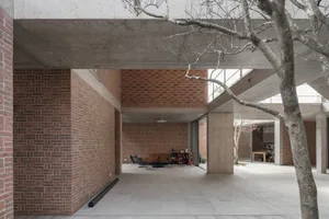 Modern living room with brick and concrete walls and concrete ceiling, featuring comfortable seating and a fireplace.