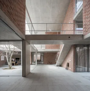 A modern office space with exposed brick walls and large windows.