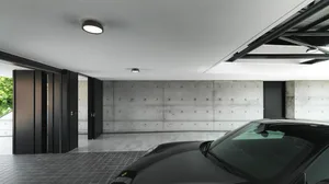 Modern minimalist car garage with concrete walls and floors, featuring a sleek, black sports car.
