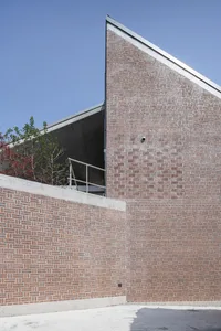 Modern building exterior featuring a red brick facade and concrete accents