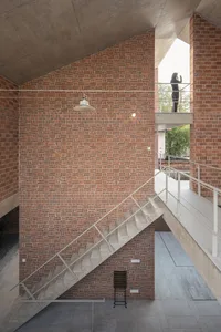 A modern industrial staircase with brick walls and concrete steps and railings