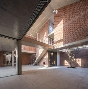 Modern interior with brick walls, glass windows, and concrete flooring.
