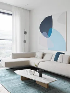 A modern living room featuring contemporary furniture with a minimalist aesthetic, including a white sectional sofa, a marble