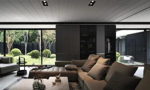 Modern living room interior with a sectional sofa, coffee table, and bookshelves.