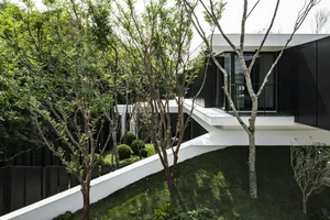 A modern residential house with glass walls and wooden accents.