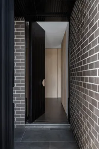 A modern doorway featuring brick and wooden elements.