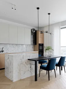 A modern residential kitchen featuring marble countertops and flooring.