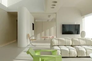 Minimalist living room with white furniture, green armchair, and a neon plastic chair.