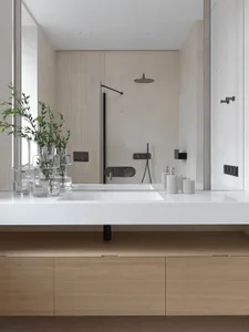 A minimalist modern bathroom with marble accents and sleek black fixtures.