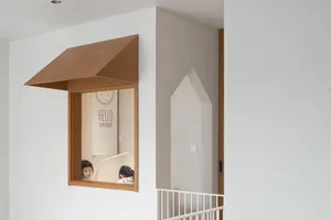 A modern children's playroom featuring a wooden window and two children playing.