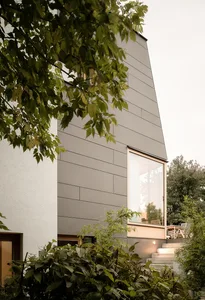 Modern minimalist house exterior with metal cladding and large windows