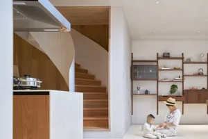 A modern minimalist residential space with a cabinet that features curved wood and concrete elements.