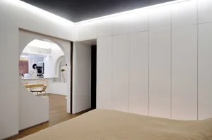 A minimalist bedroom with white paneled walls