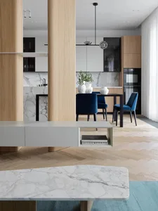 A modern minimalist kitchen featuring marble countertops and wooden furniture.
