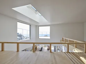 Minimalist living room with large windows, hardwood floors, and beams.