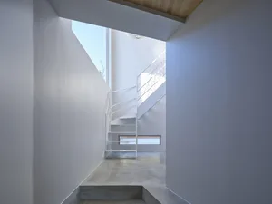 A white concrete staircase with metal railings in a modern interior design setting.