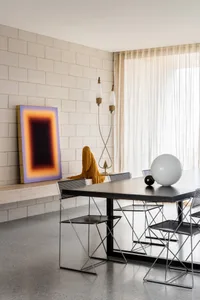 A modern dining room featuring a metal-framed table and chairs.