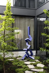 An abstract, blue metal sculpture designed for outdoor display.