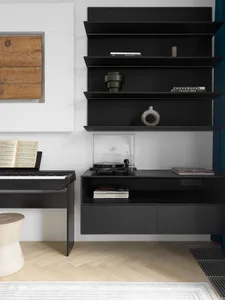 A modern music room featuring black shelves with a turntable, a piano, and sheet music.